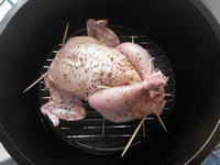 温めたダッチオーブンに丸鶏が入れられています。