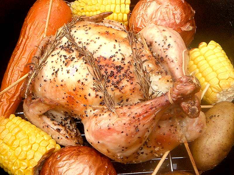 ダッチオーブンの中で焼きあがったスタッフドチキンがニンジンや小天ネギなどの野菜と一緒に映っています