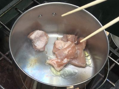煮込み用の鍋で鶏もも肉を焼き目が付くまで炒めている